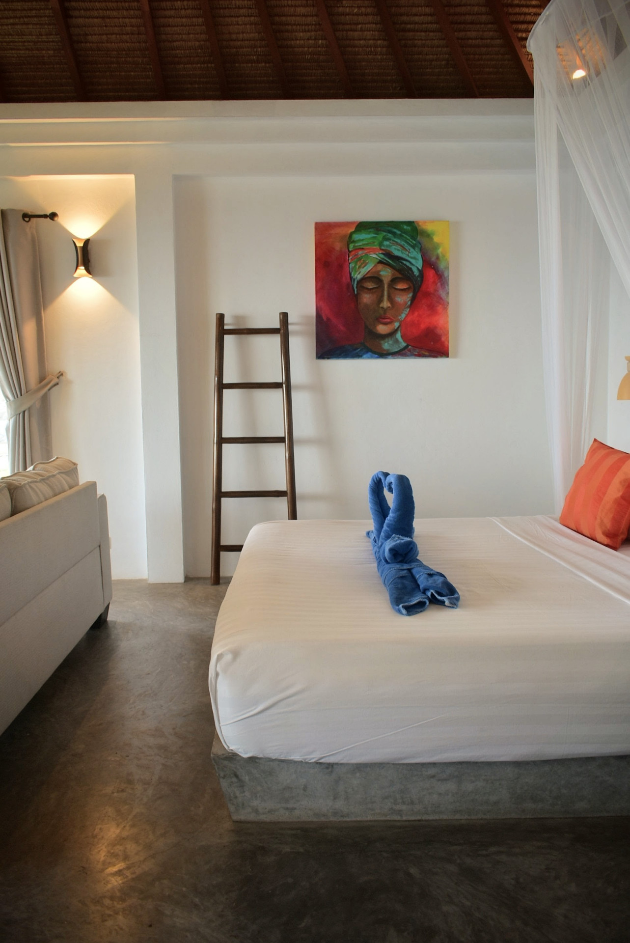 Bedroom with vaulted roof and artwork in The Trevally House