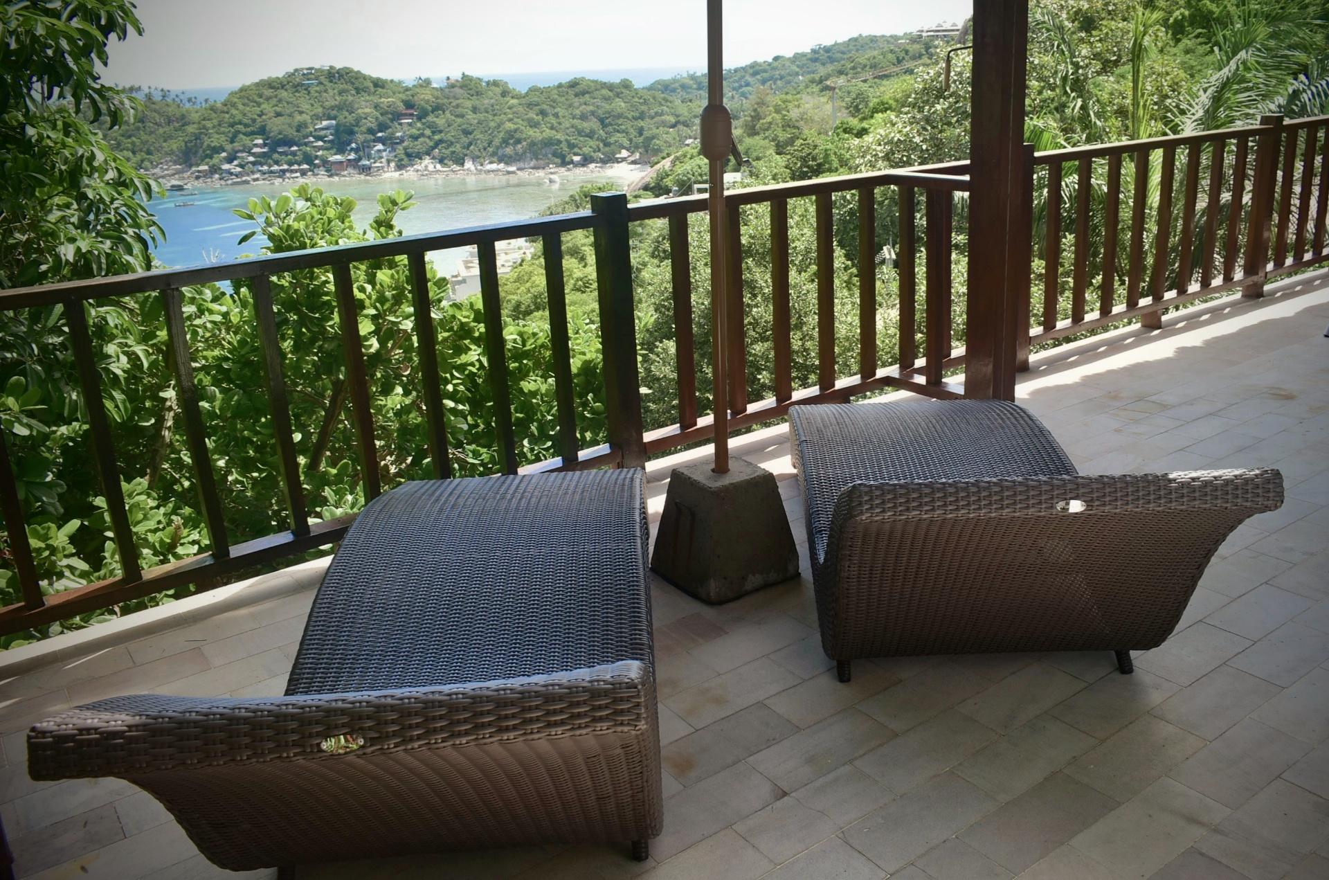 Covered terrace with sun loungers overlooking the bay at The Trevally House