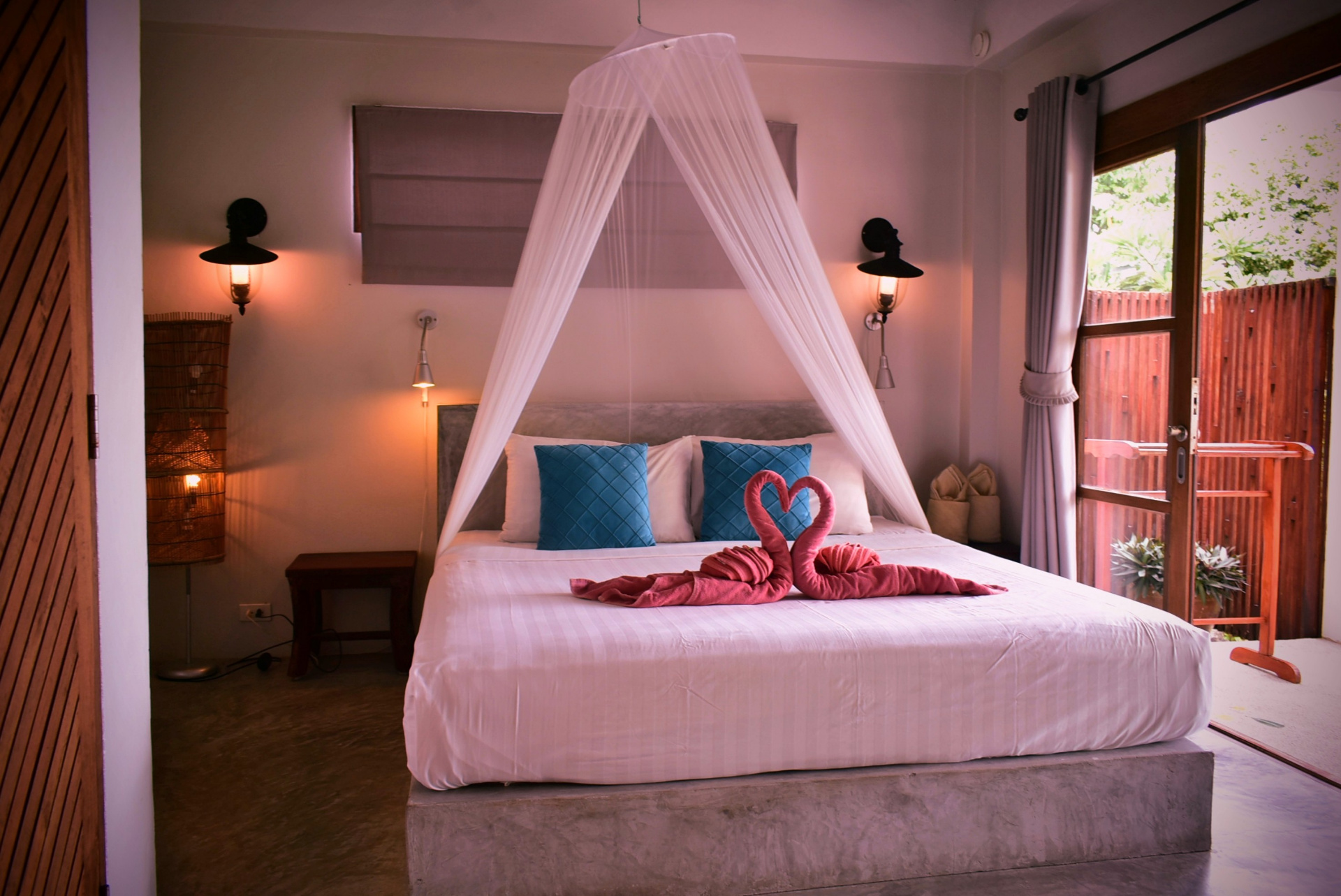 Canopy bed with mosquito net and romantic towel art in The Fisherman’s House