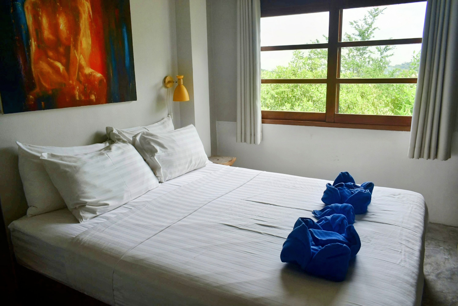 Downstairs bedroom with artwork and garden view in The Sailfish House